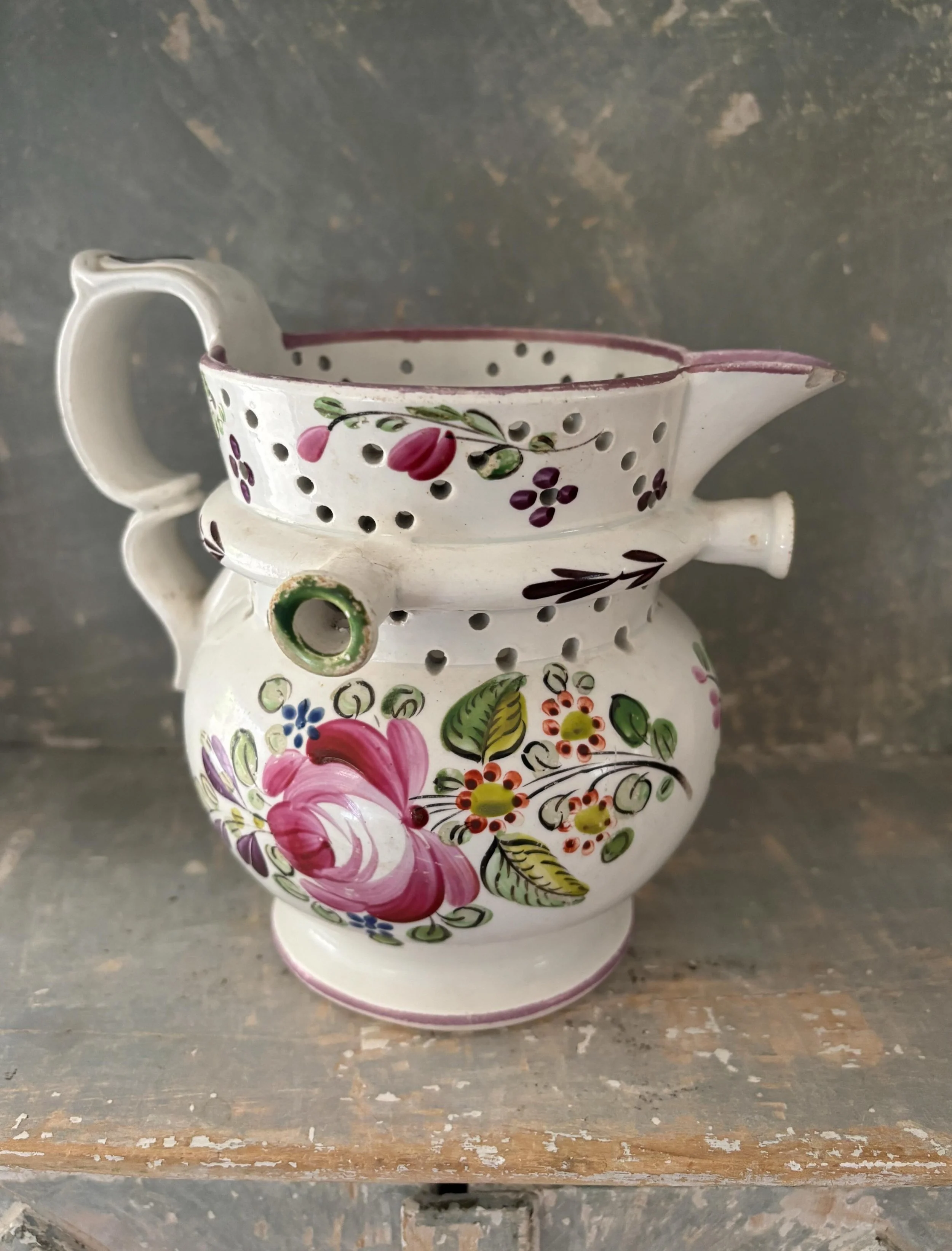 FOR SALE A very rare antique hand painted earthenware puzzle jug, circa 1830. The floral decoration is similar, but not a fit, to jugs originating from Bristol potteries during this period but the shape and some elements of the decoration are both ve