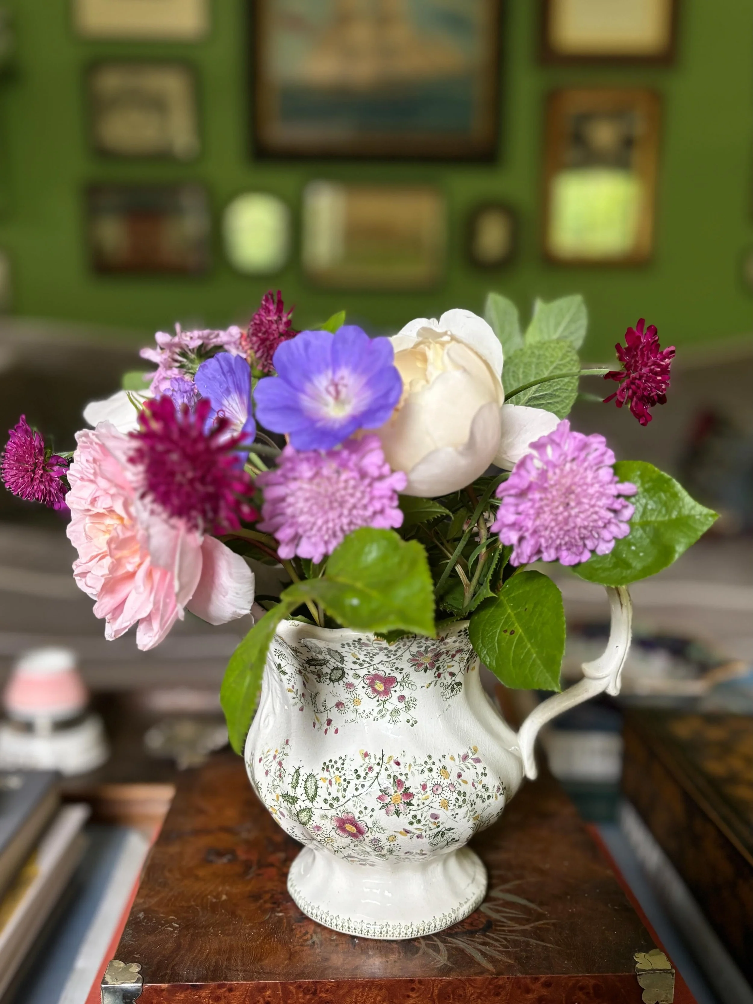 FOR SALE A beautiful mid 19th century moulded transferware jug with lion handle. The delicate floral decoration is transfer printed in dark green and hand coloured in pink and yellow. It has a handsome moulded spout and ornate handle with transfer pr