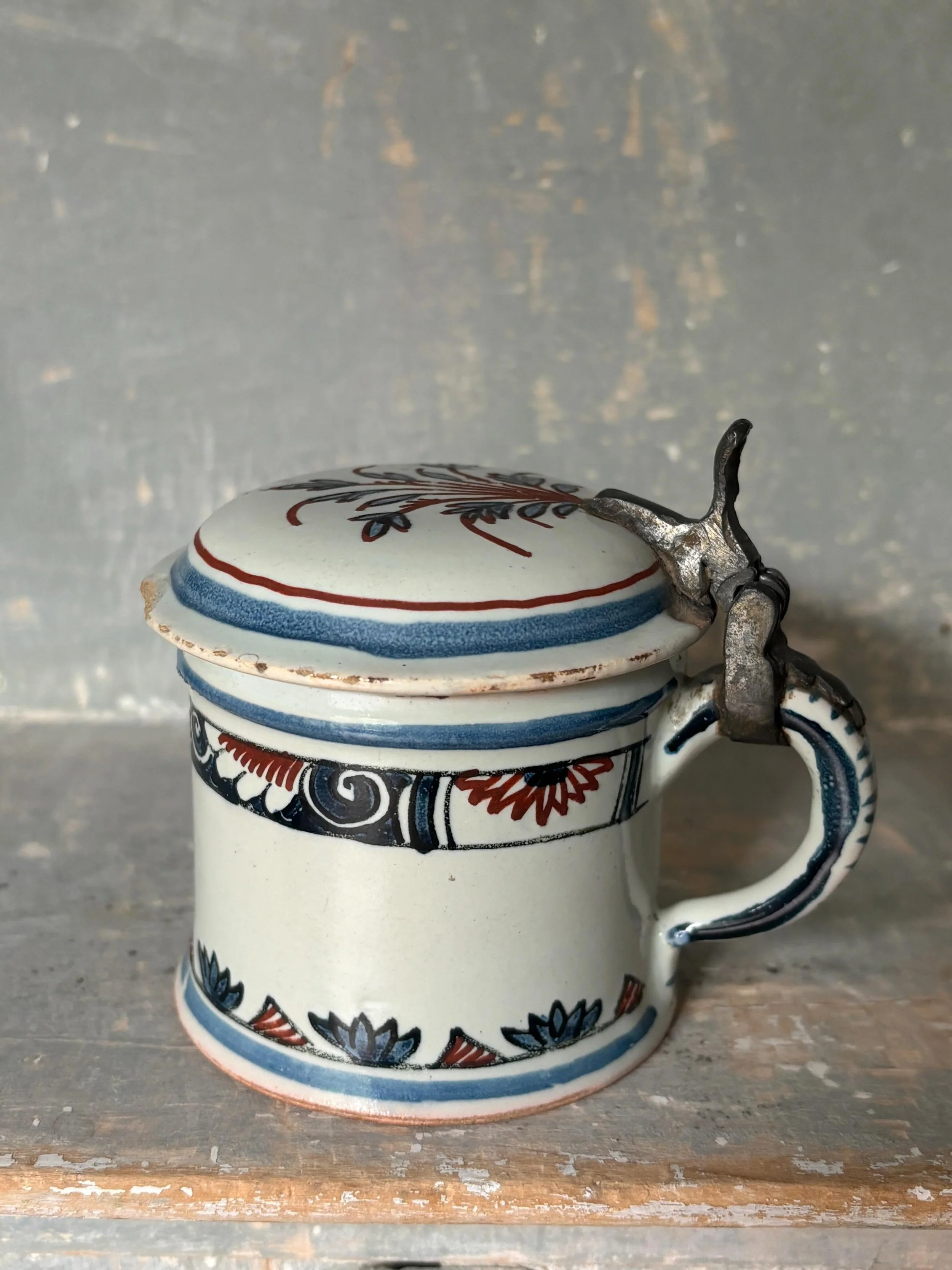 FOR SALE An 18th century French faience (tin-glazed earthenware) covered mustard pot with pewter handle and wonderful striped handle. 

It has a lovely frieze, a band of geometric pattern, scrolls and foliage. It is the most beautiful little piece of