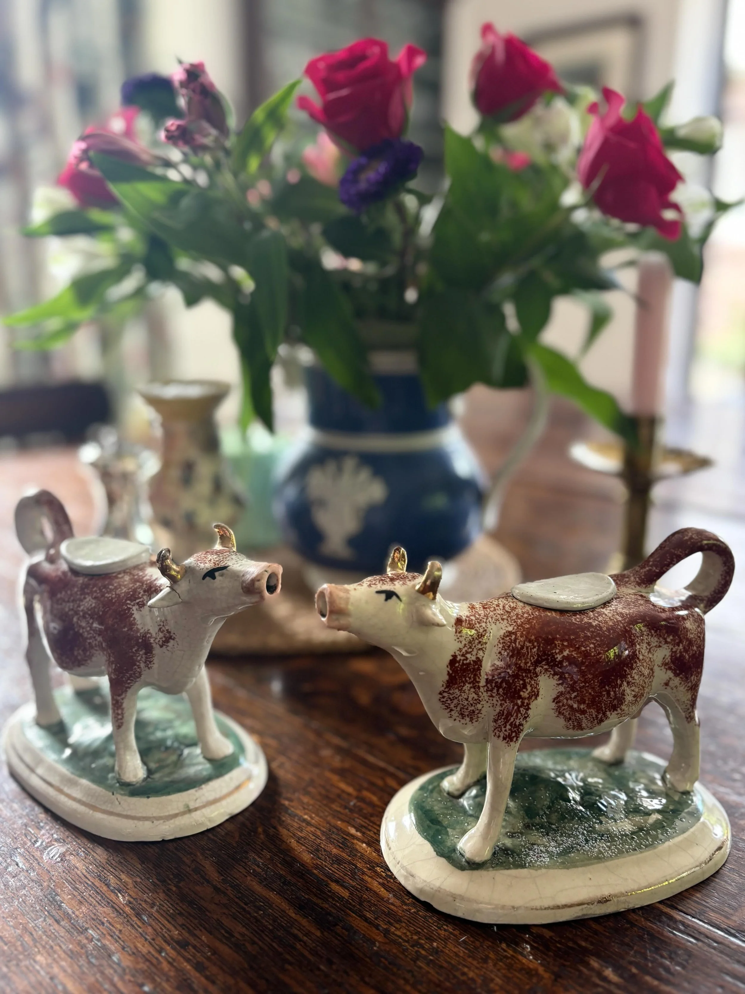FOR SALE Two classic late 19th century Staffordshire pottery cow creamers. They have brown sponge-decorated markings with pink noses and gilt horns, each cow standing on a green oval base. They make such wonderful decorative pieces of pottery, ideal 