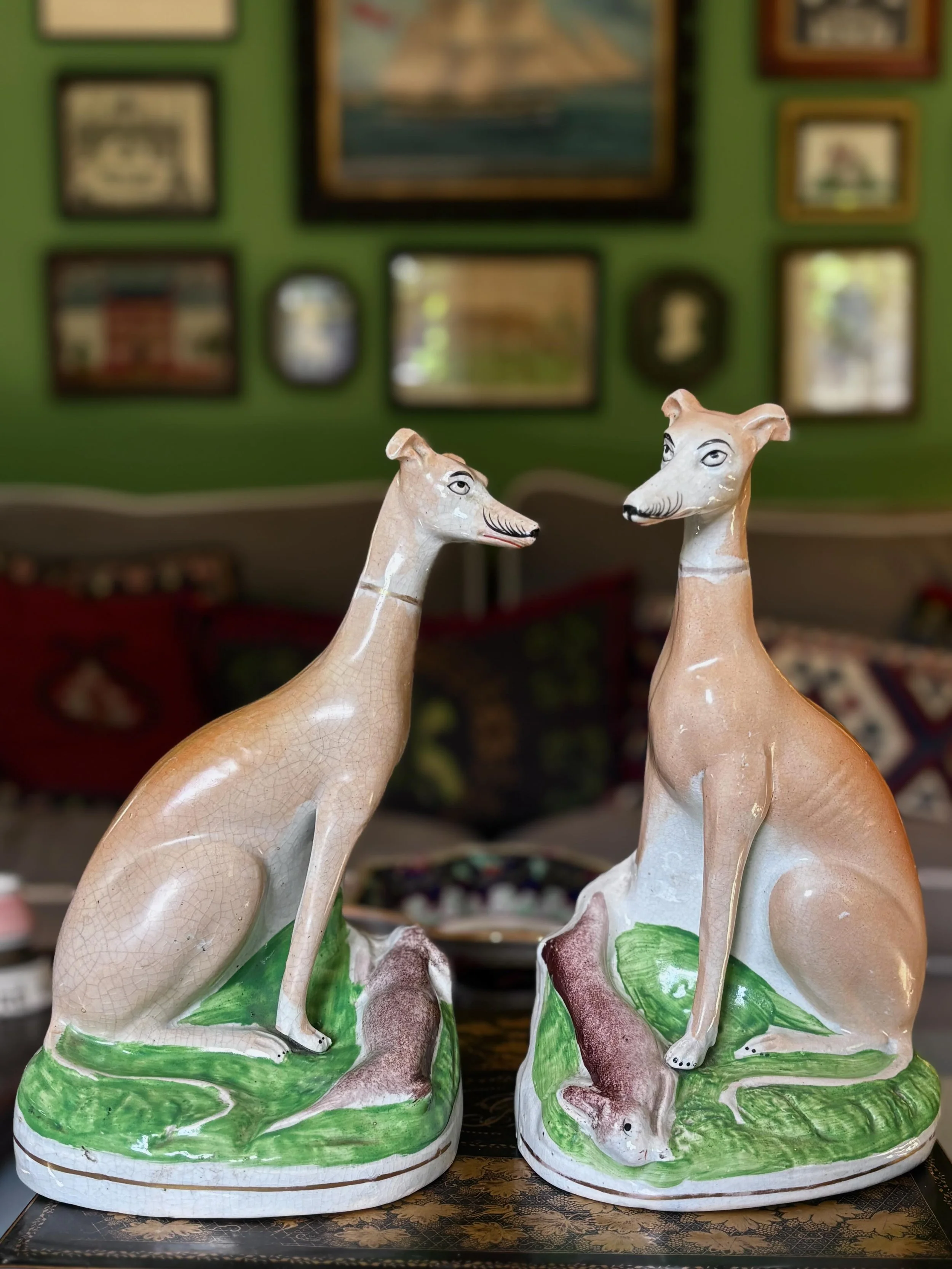 FOR SALE A superlative pair of antique Staffordshire pottery seated whippets, circa 1860. They are modelled on naturalistic oval gilt-lined bases each with a rabbit at their feet. They are beautifully modelled with classically haughty expressions on 