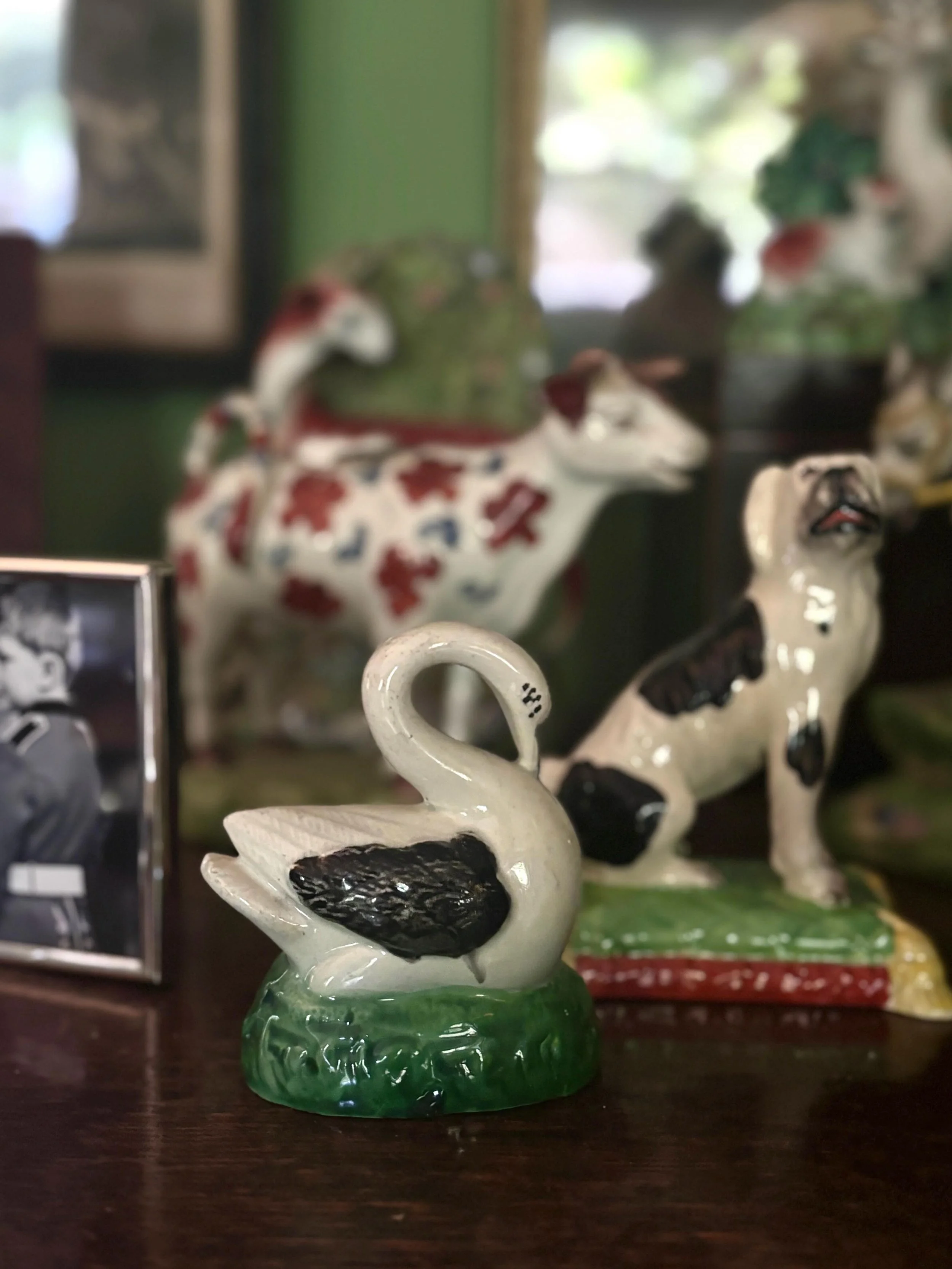This most recent arrival is about to join my collection of miniature Staffordshire figures: the prettiest little swan shown here with a fellow black and white piece, this splendid Staffordshire pottery hound on a tasseled cushion.

#staffordshirepott