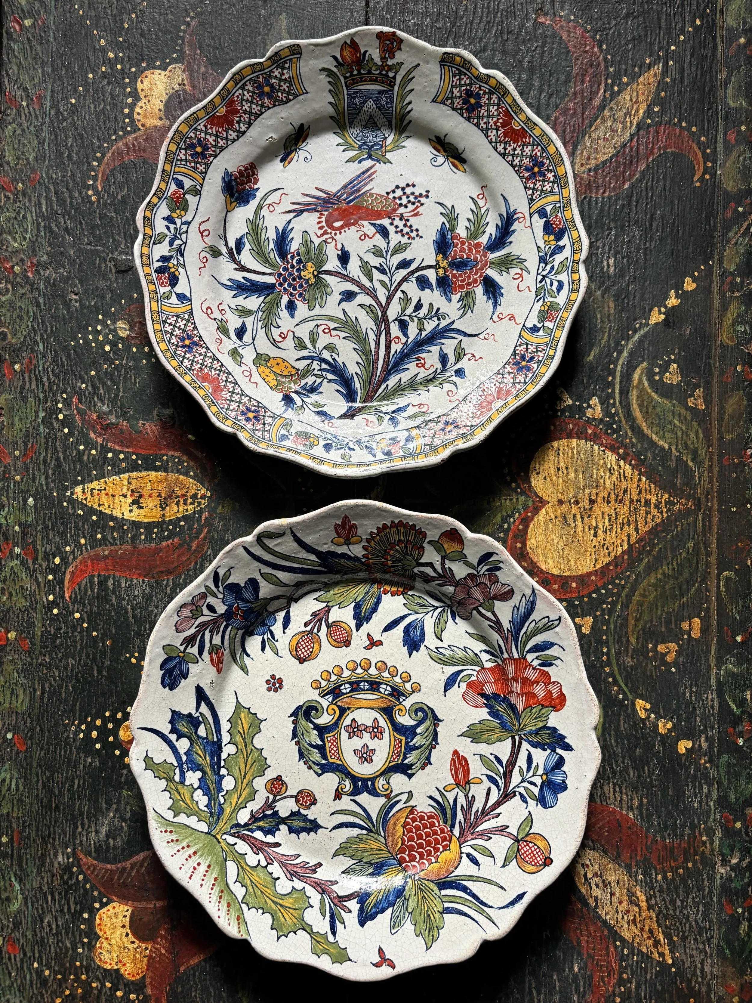 FOR SALE Two superlative late 18th century Rouen faience hand-painted plates. Both plates are heavily decorated with botanical motifs including pomegranates, which were symbols of abundance and prosperity. Each also features a stylised heraldic coat 