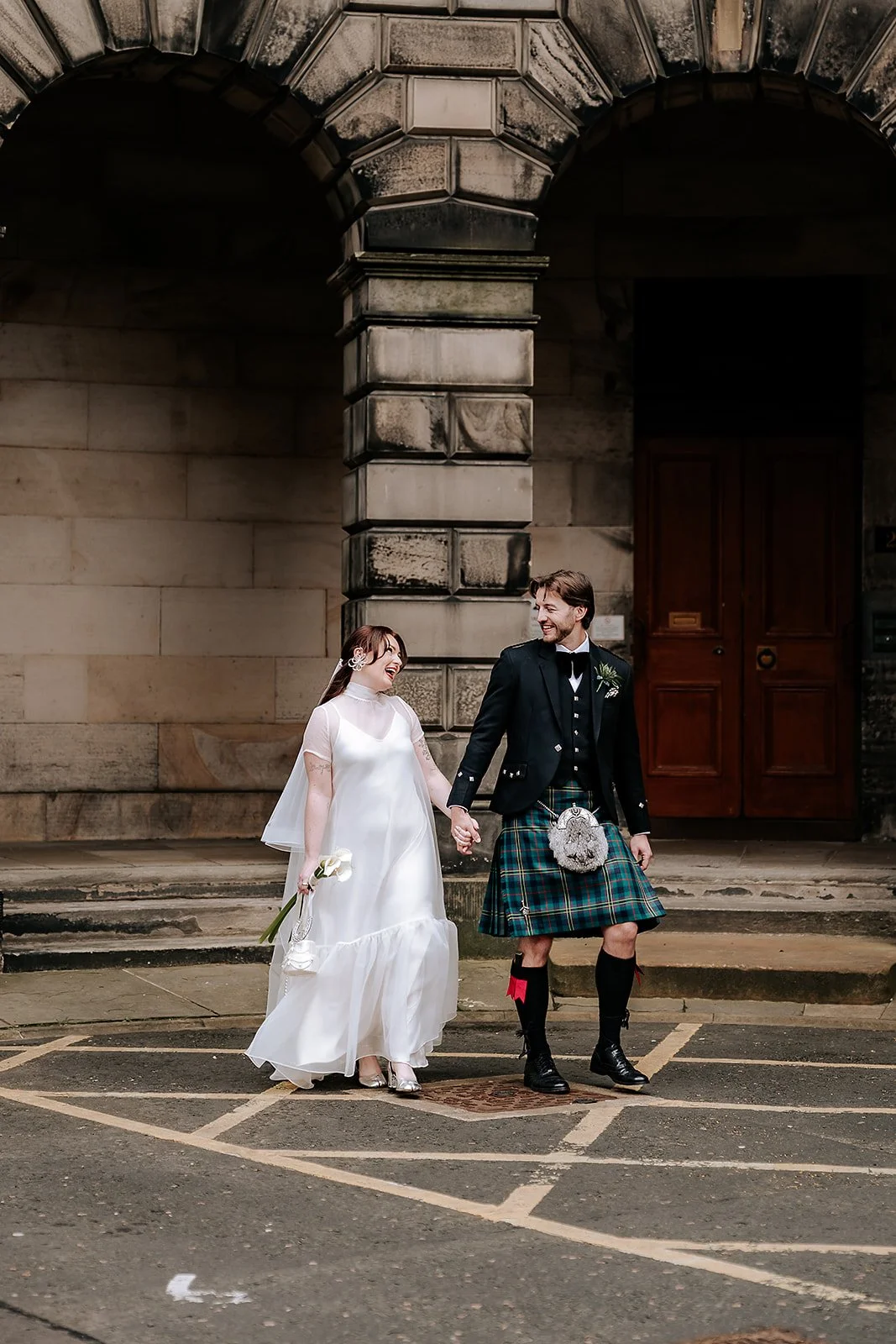 •	Just married couple exploring Edinburgh Old Town after City Chambers wedding