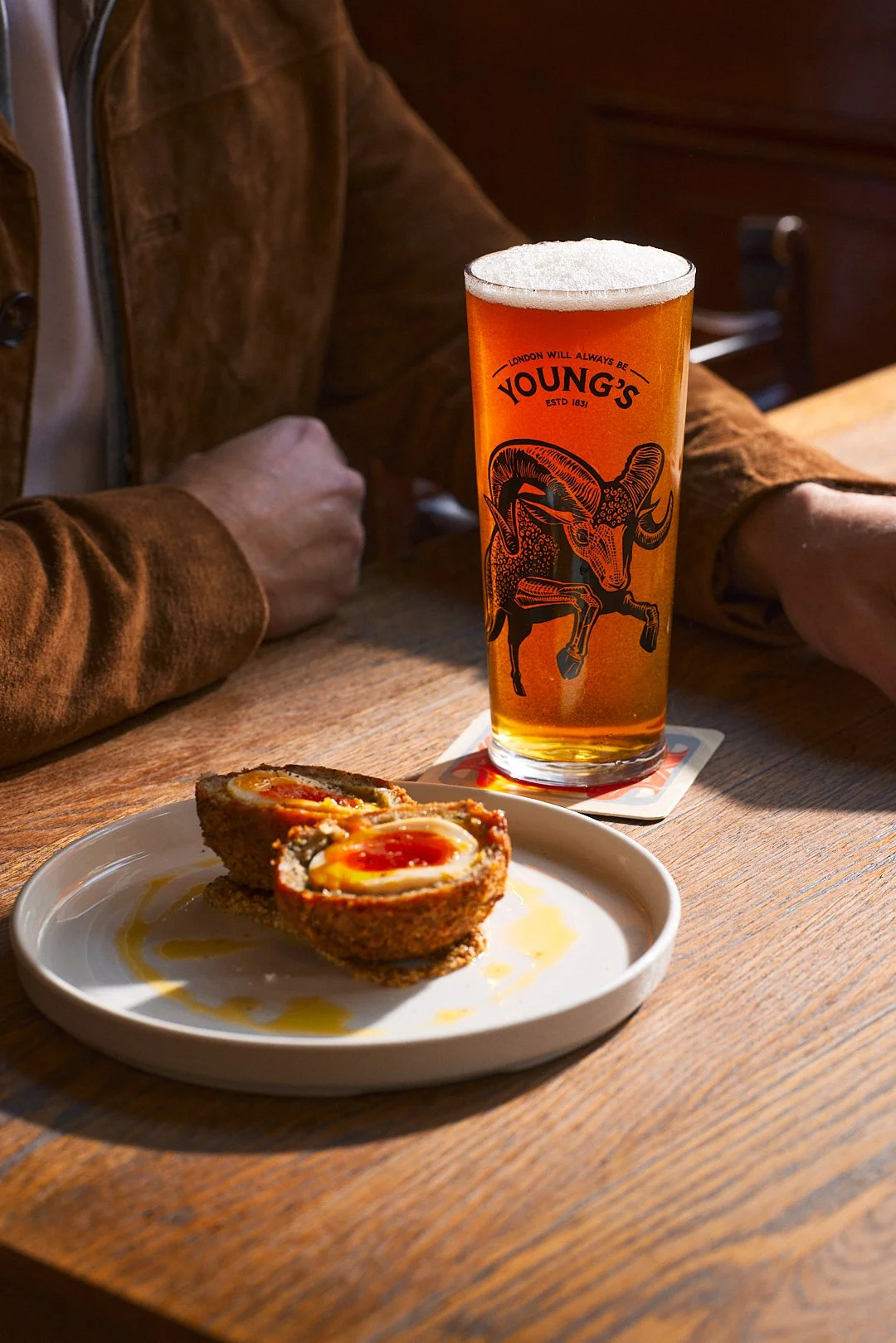 Pint of Young's London Original on a pub table, from a content shoot by Rob Pinney Studio