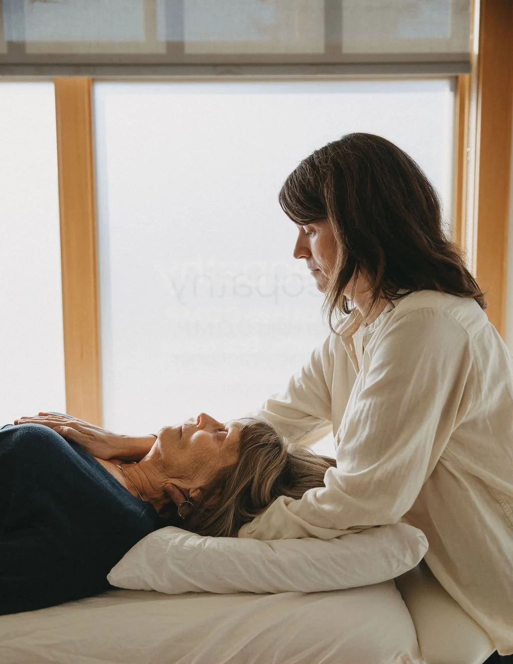 A woman receiving osteopathy from a therapist.