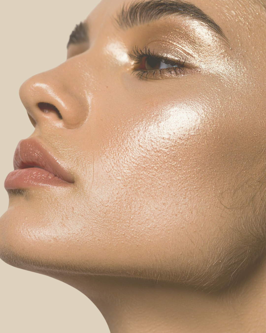 Close-up of a woman's face with highlighted cheek, eye makeup, and natural skin texture.