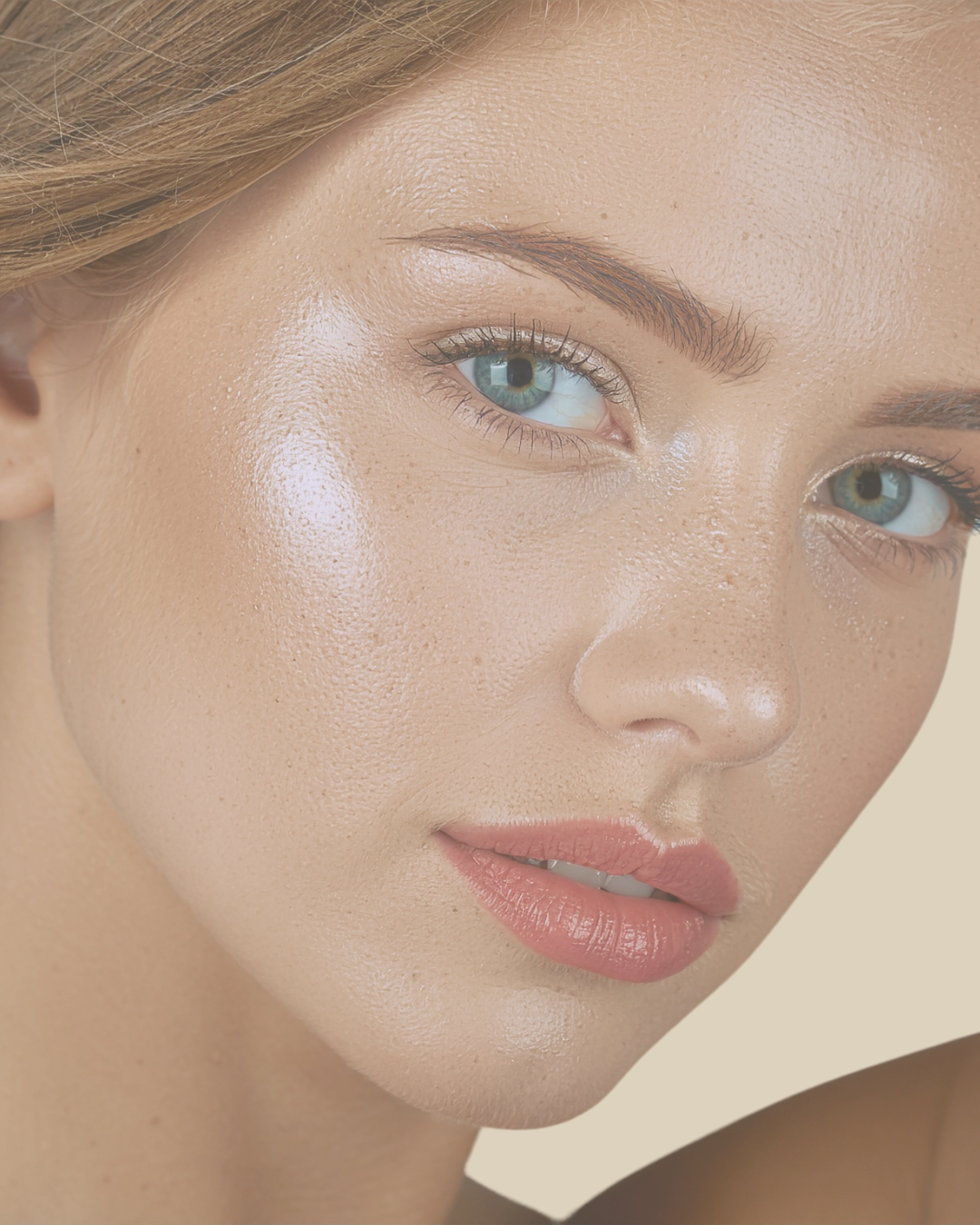 Close-up of a woman's face with smooth skin, light makeup, light pink lips, and blue eyes