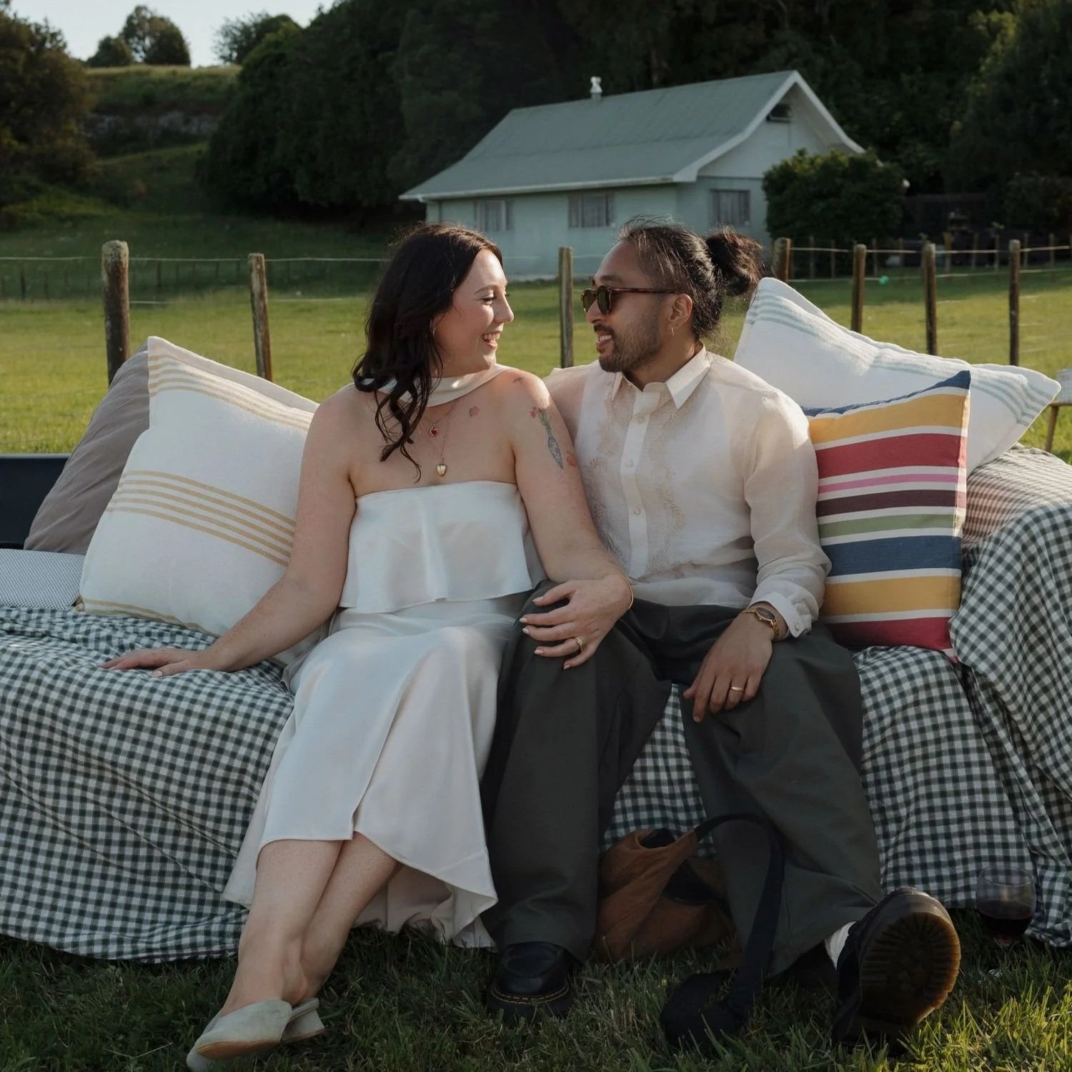 Bride and groom sitting together on a couch. Beach wedding in Wellington New Zealand. Beautiful natural makeup look