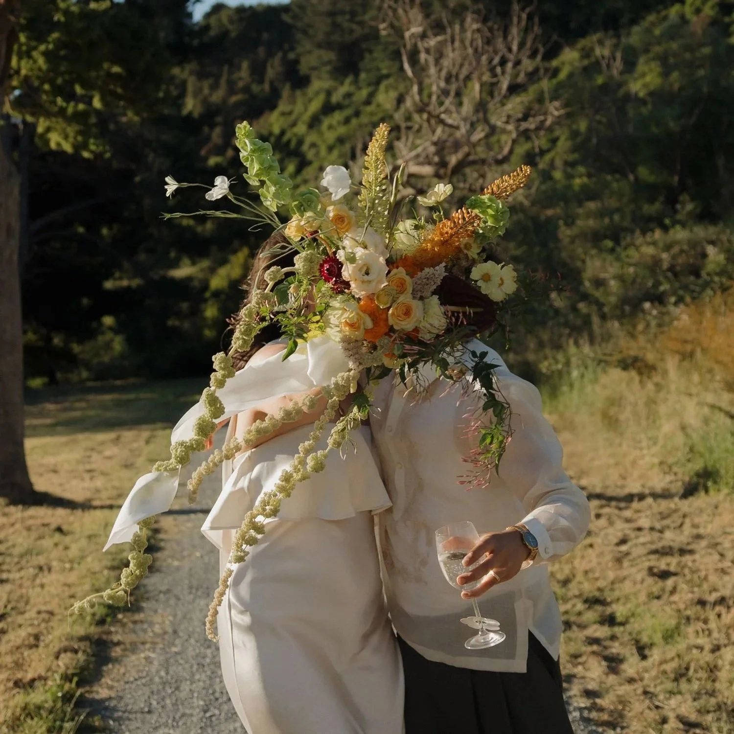 Wedding day. Bride kissing the groom behind beautiful bouquet of flowers