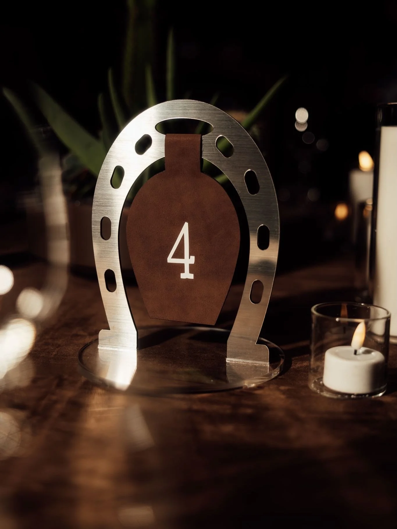 WESTERN GLAMOUR, ELEVATED 🤎

Rich chocolate velvet linen, steel blue velvet napkins, custom horseshoe table numbers finished with leather detailing, sculptural cacti centrepieces, flickering candlelight, and bespoke wanted-style menus crafted down t