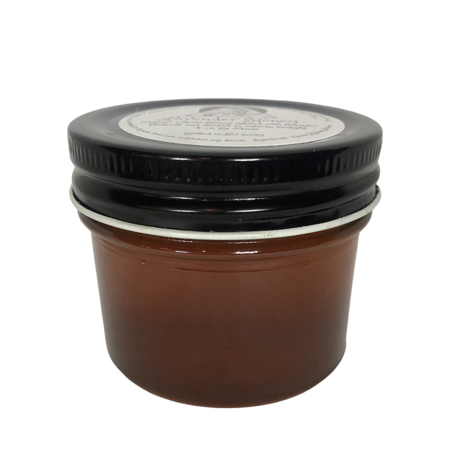 Side view of clear glass jar with lavender honey and black lid.