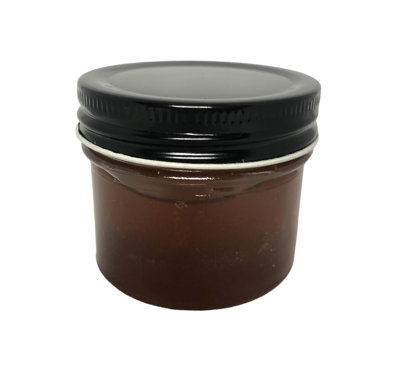 Panned out view of clear glass jar with lavender honey and black lid.