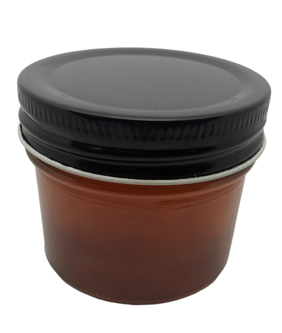 Close up view of clear glass jar with lavender honey and black lid.