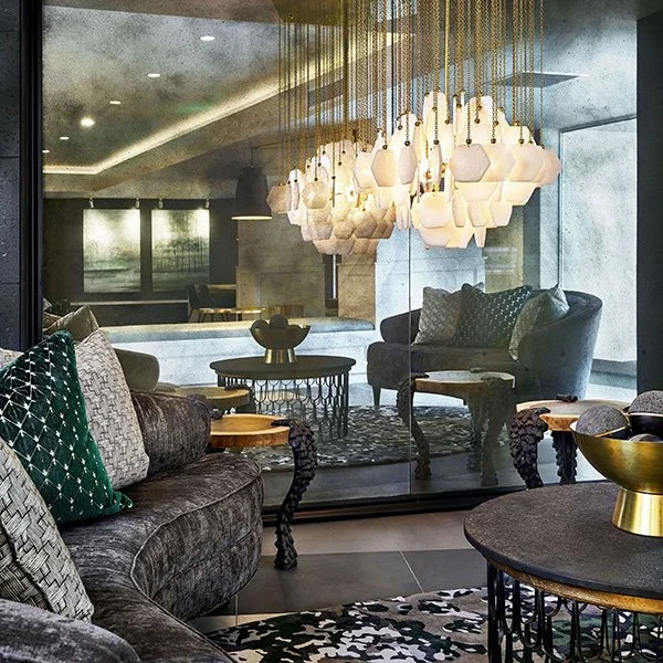 A mirrored lobby with large chandelier.