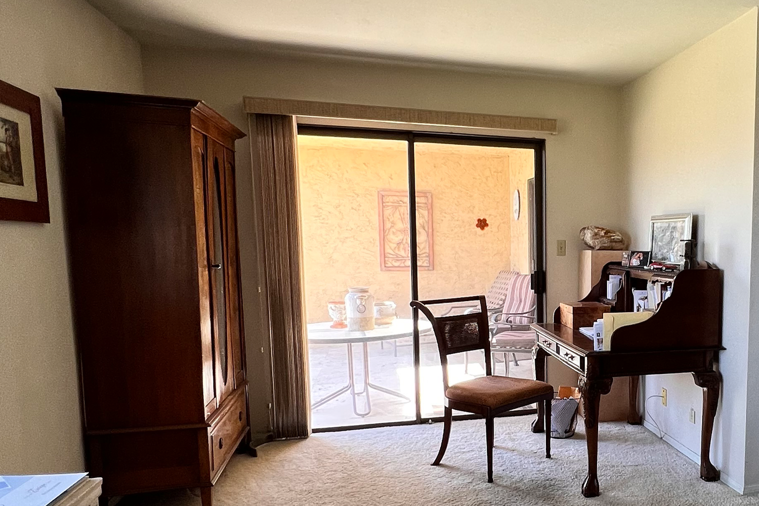 1973 Palm Desert condo living room prior to remodel, dated dark wood armoire and beige carpet.