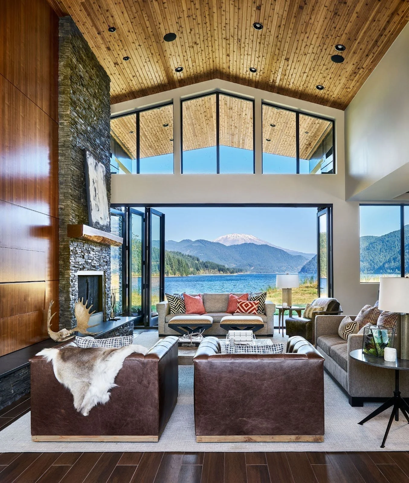 A spacious living room with a large sliding door leading to a lake.