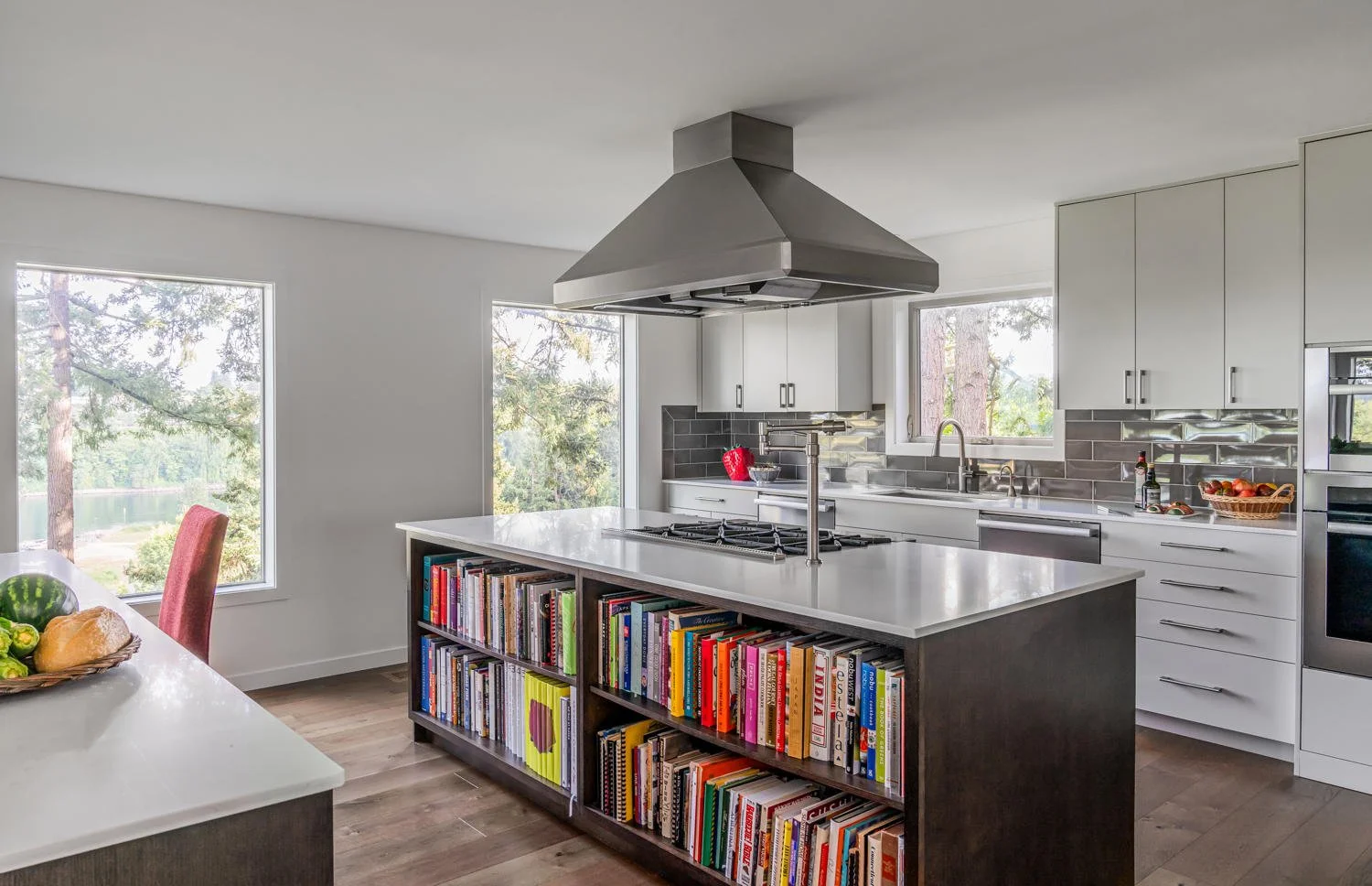 A kitchen with cookbook storage and a ceiling mounted ventilation hood.