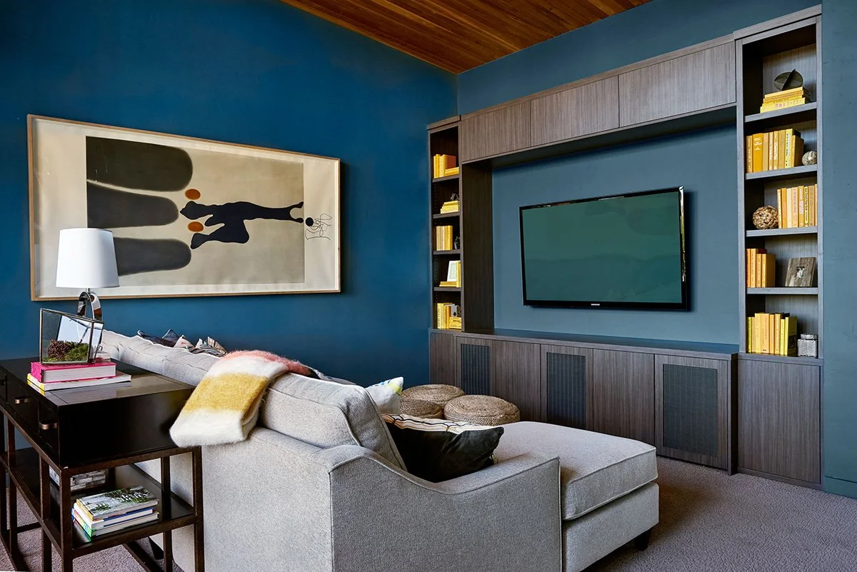 An entertainment room with deep teal walls.