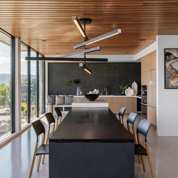A commercial space with a long table and geometric overhead lighting.