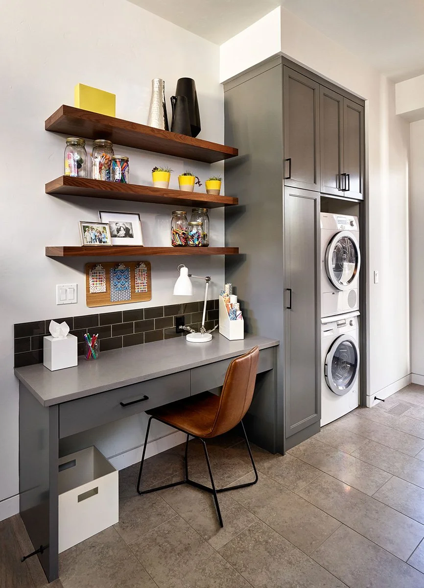 A mudroom with laundry machines and a small desk.