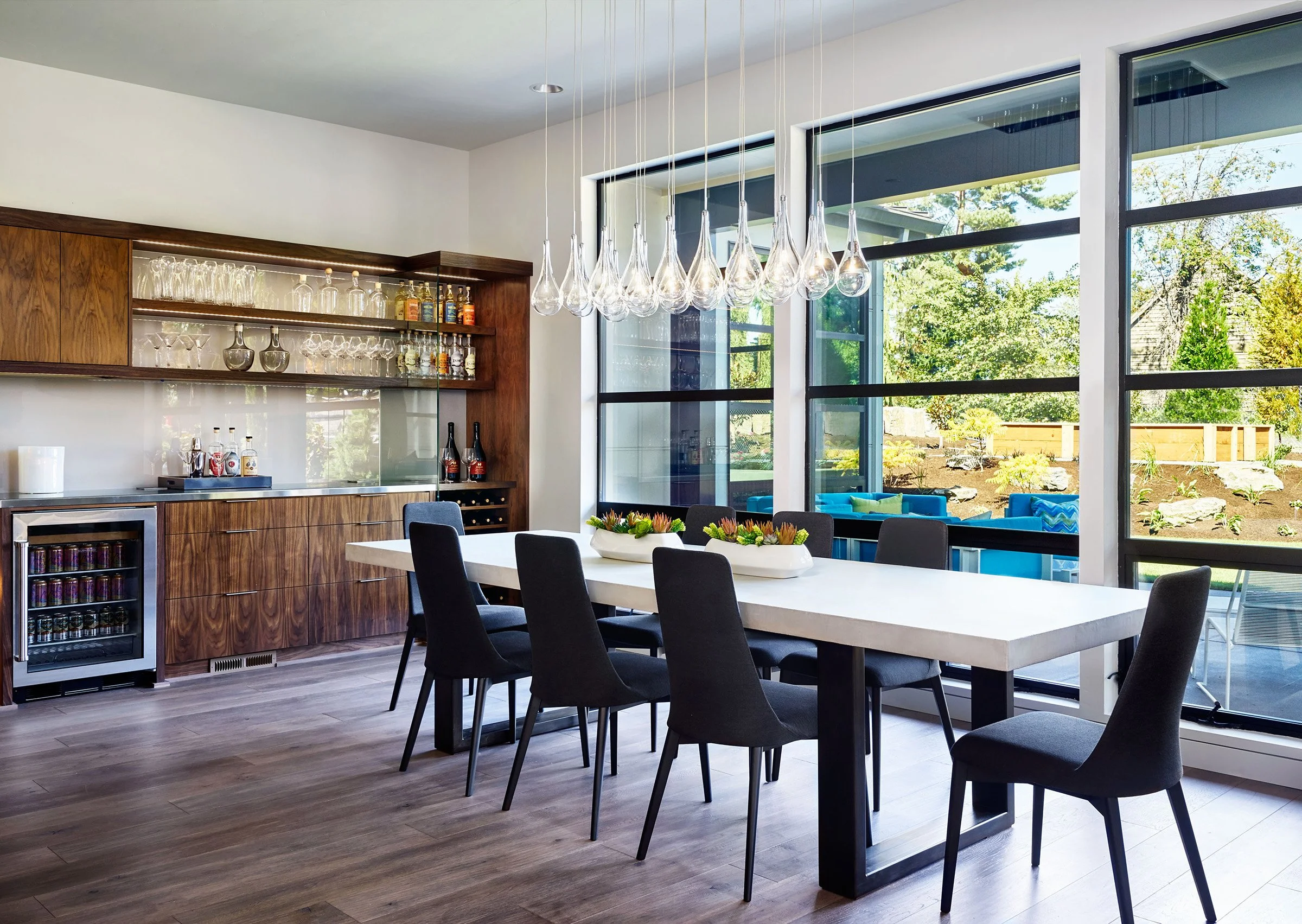 A dining table in front of large windows.