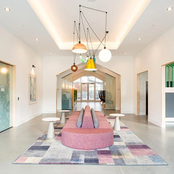 A double sided pink sofa in a modern amenity area.
