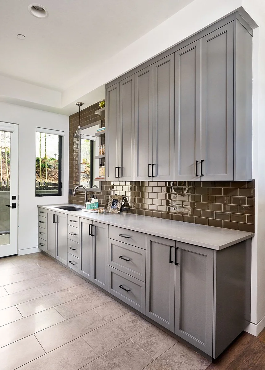 A mudroom with glass tile and storage.
