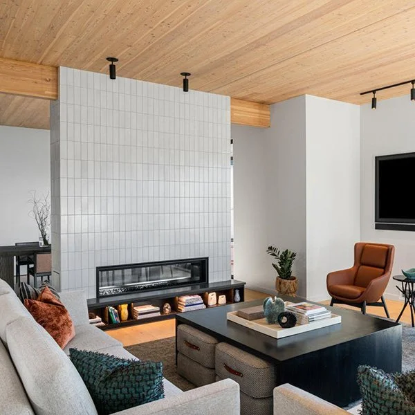 A seating area with a large grey tiled fireplace.