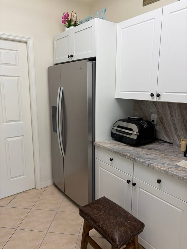 Full height refrigerator side panel and a massive full-depth upper cabinet finish off this galley style kitchen update. 