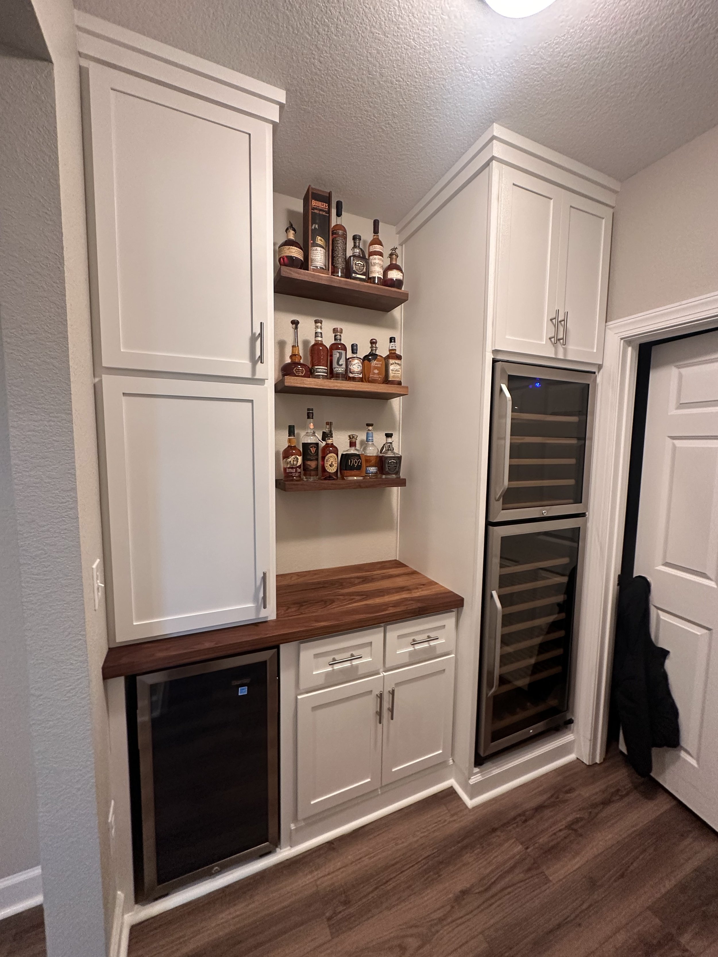 Wine Bar with fridges, walnut top, an floating walnut shelves with light (turned off in this photo)