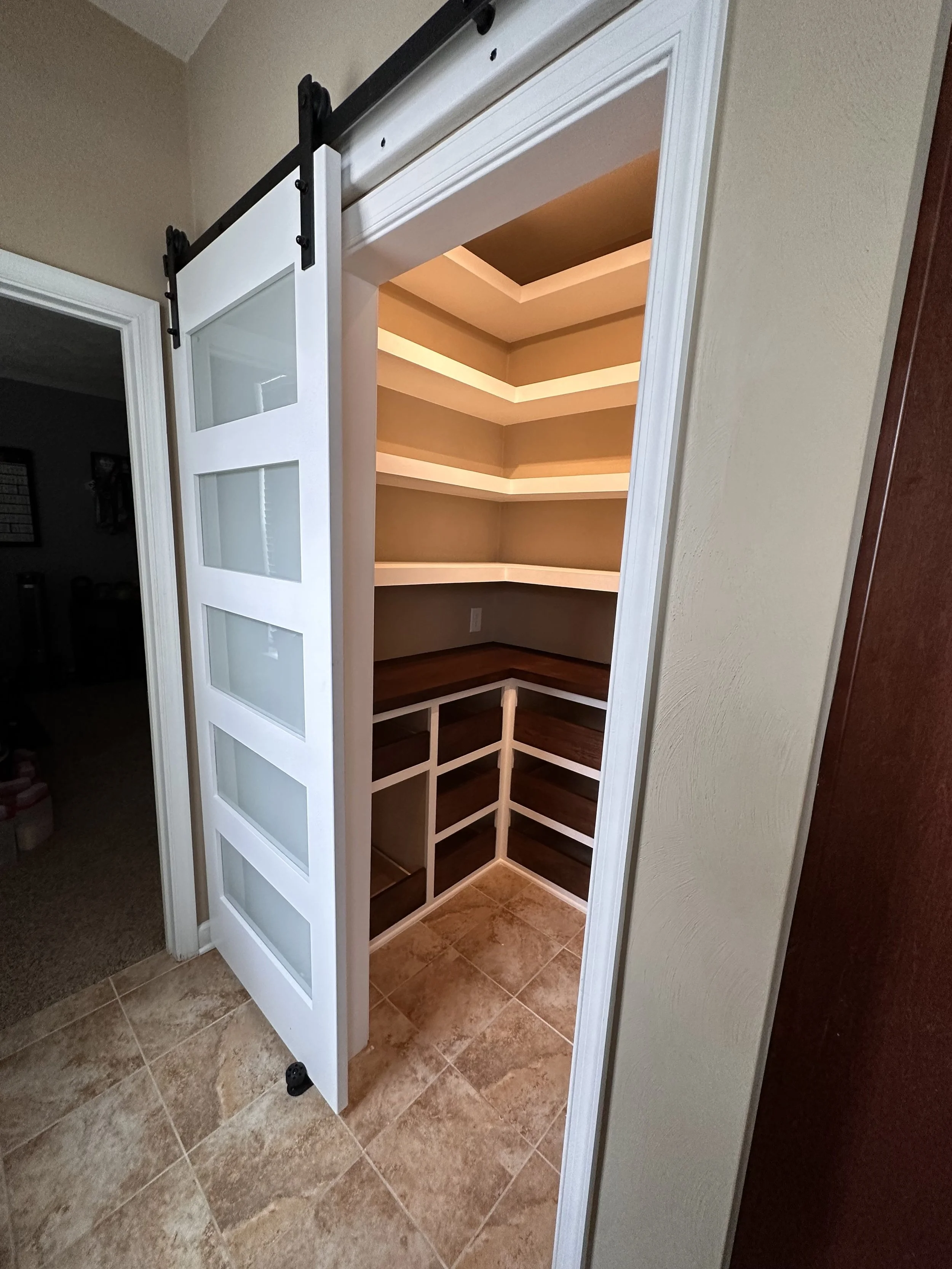 Small pantry with glass barn door