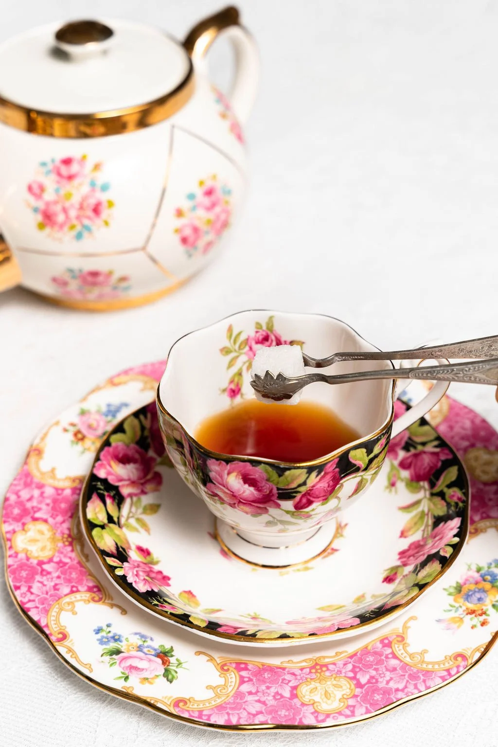 Elegant floral teacup set with sugar cube and teapot
