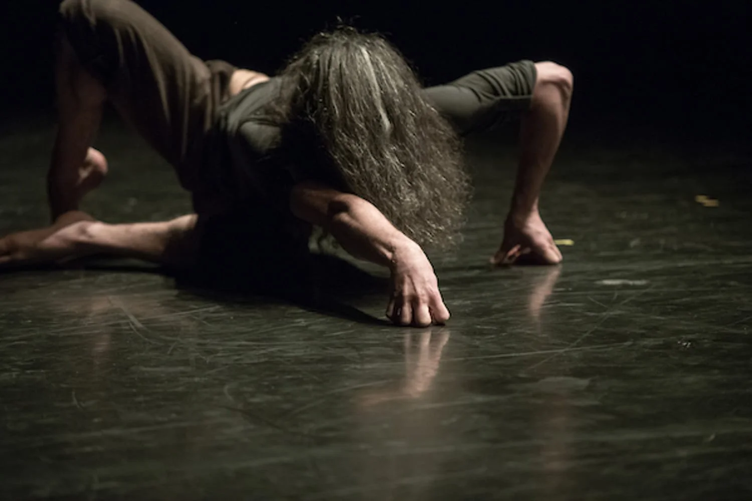 Bert crawling over the black floor, his long wild hair covering his face