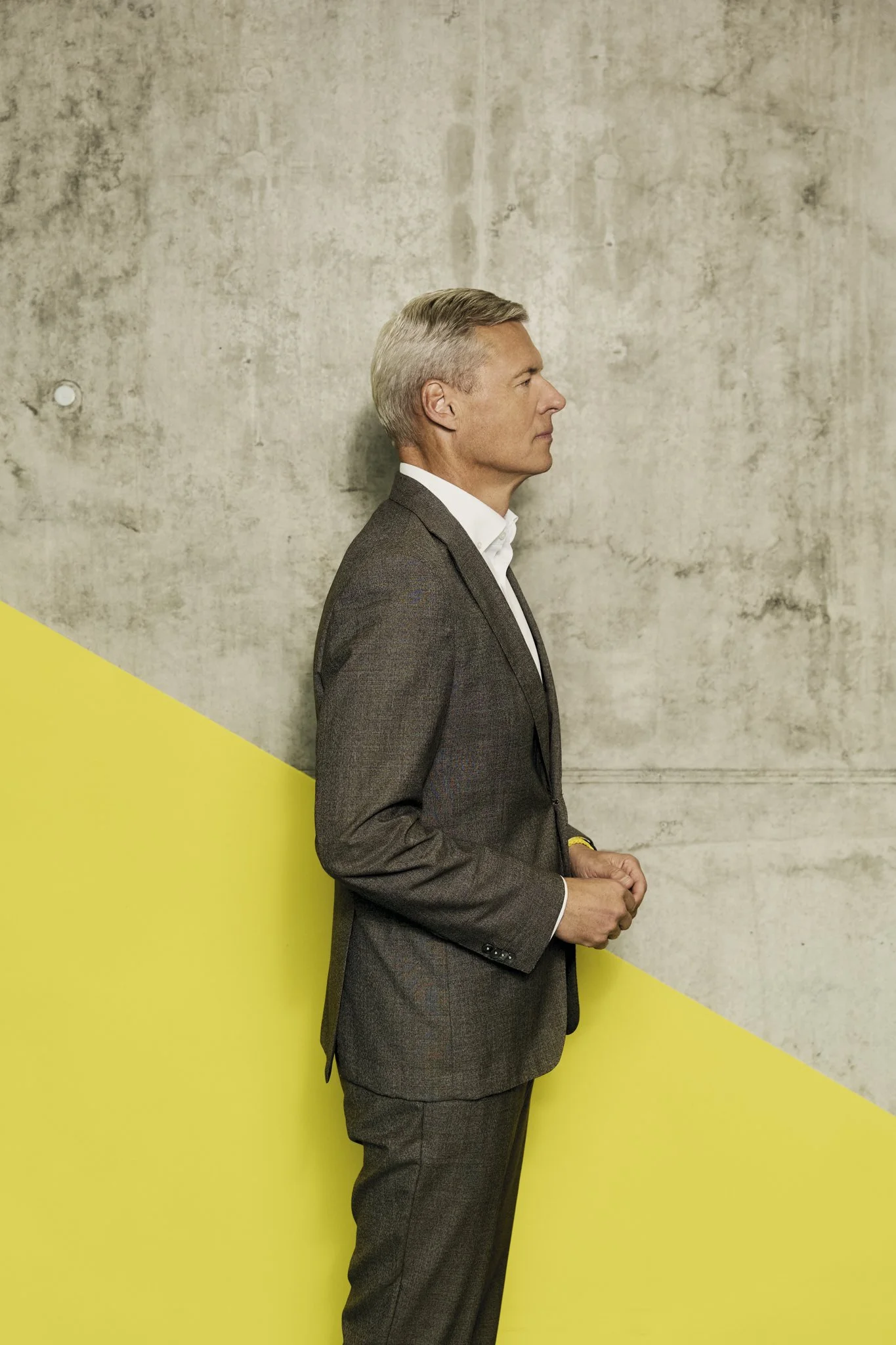 Executive Portrait eines CEOs im Profil – grafischer reduzierter Hintergrund, klare Linien und Haltung, Business Fotografie auf höchstem Niveau