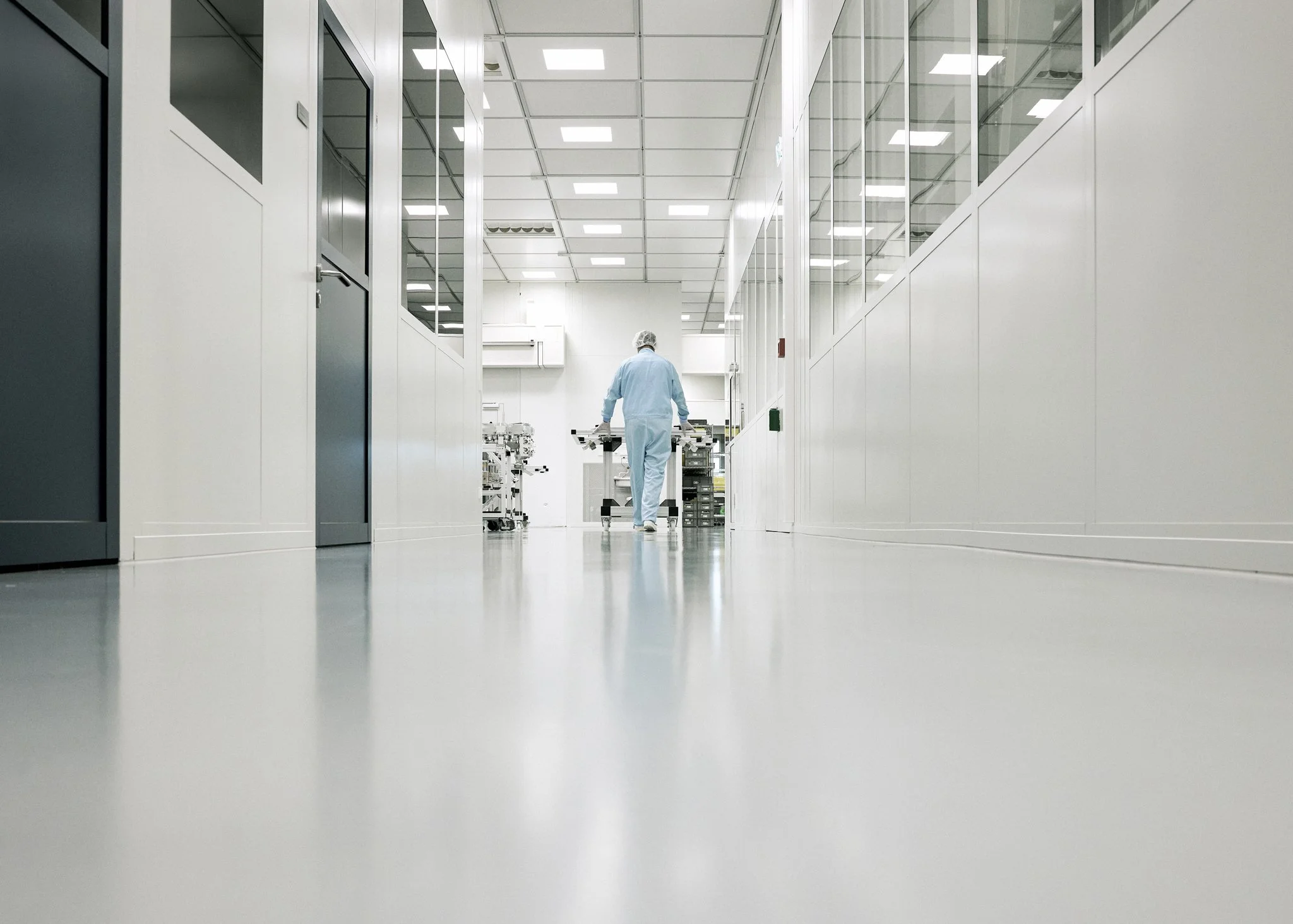 Unternehmensreportage bei TRUMPF, Mitarbeiter im Reinraum Gang, klare Perspektive, High Tech Umfeld. Reinraum