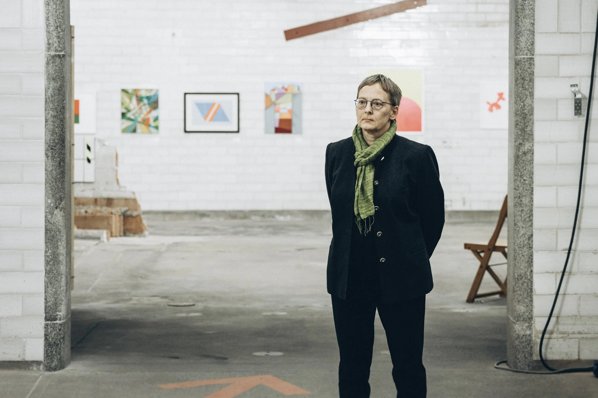 ortrait einer Besucherin im dunklen Outfit mit grünem Schal, Kunst Ausstellung und Auktion in Stuttgart, Eventfotograf