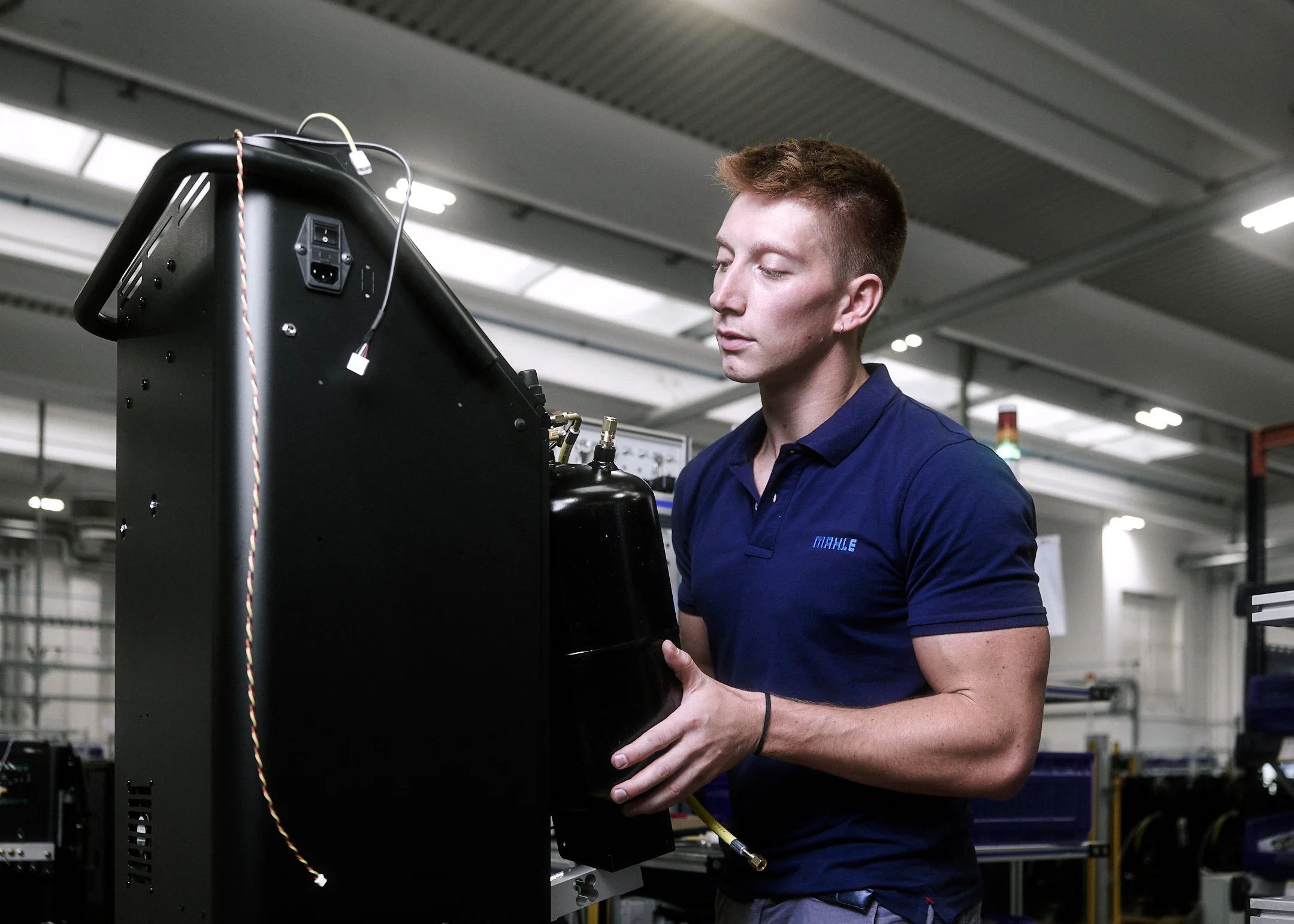 MAHLE employee working on an industrial unit inside a production hall