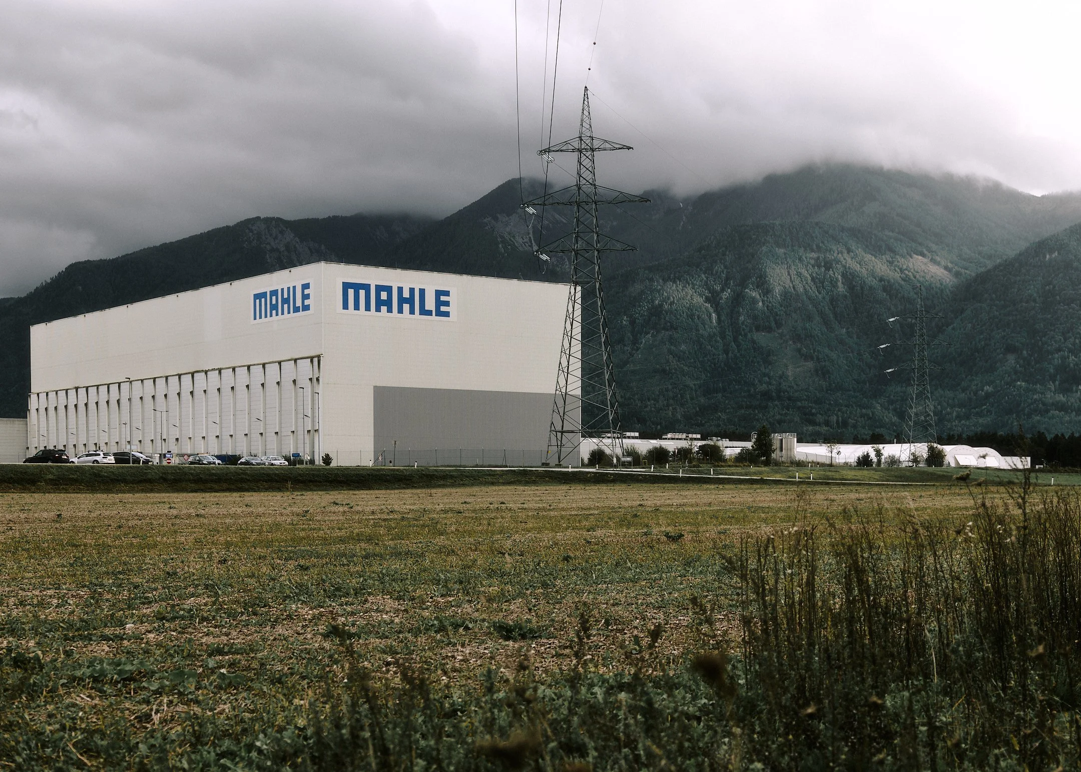 MAHLE building exterior with mountains in the background under cloudy sky