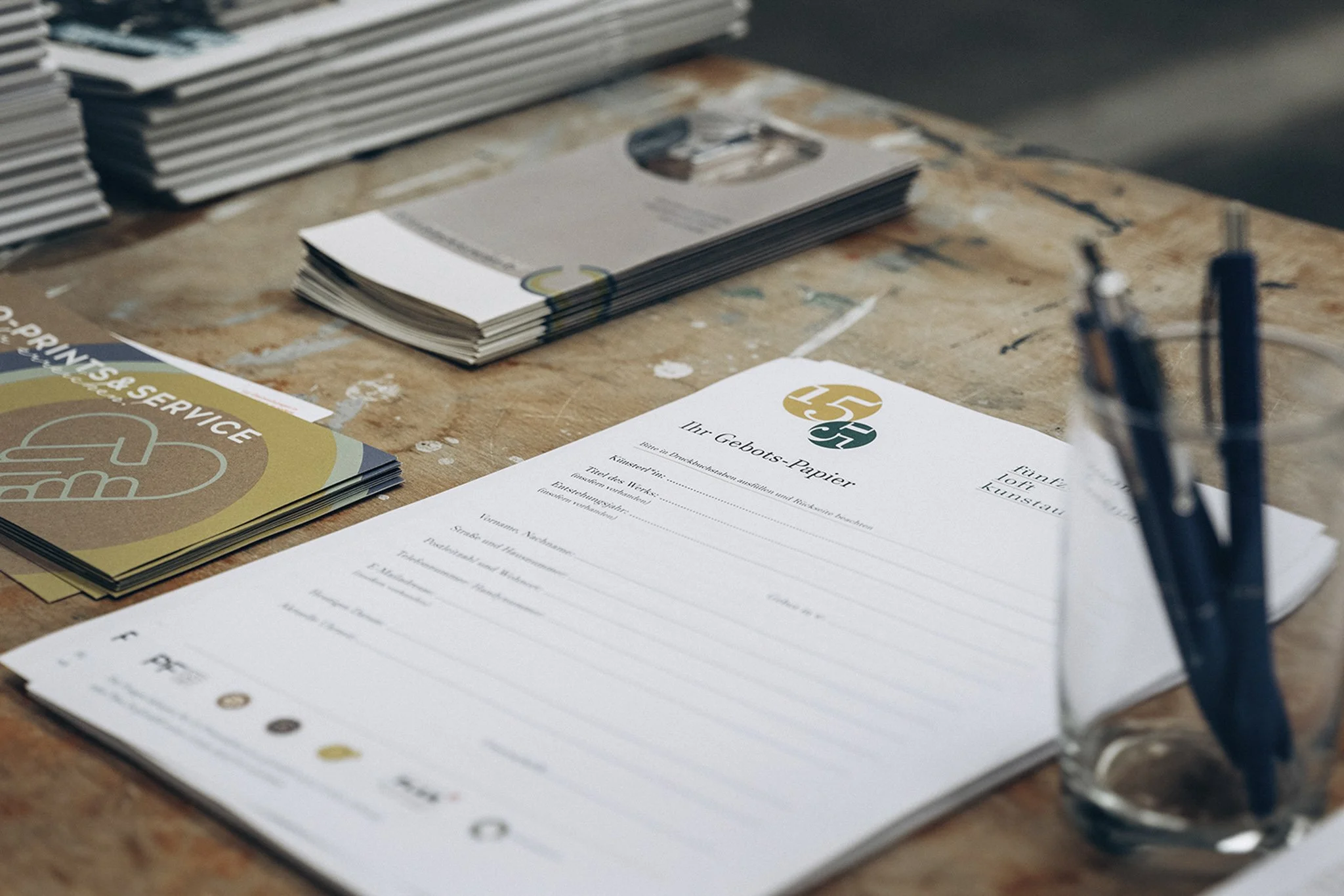 Tisch mit Flyern, Notizblock und Stiften, Printmaterial und Gästeinfos bei Kunst Ausstellung und Auktion, Stuttgart Eventreportage