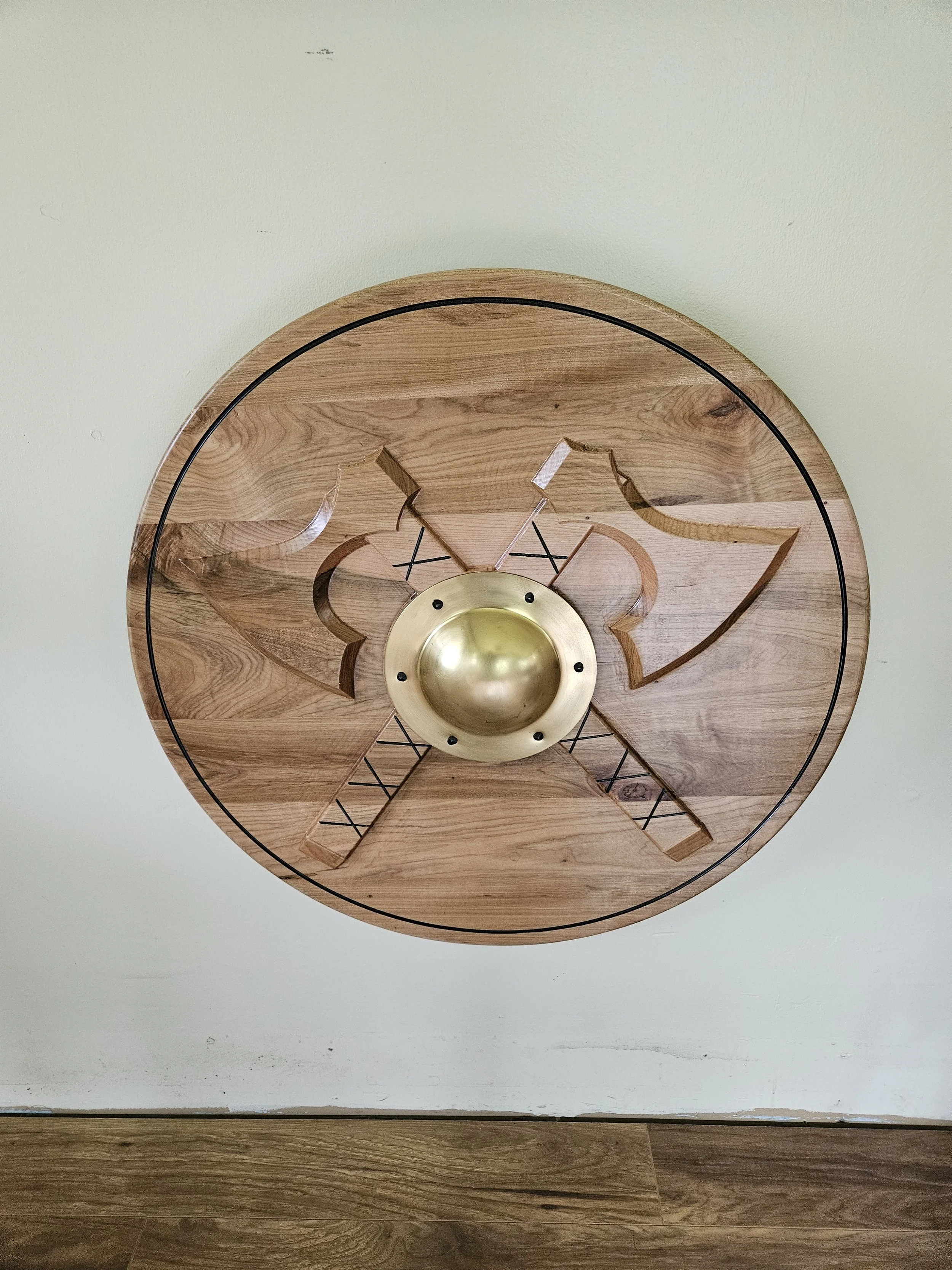 Solid Maple shield with crossed axes carved into the face