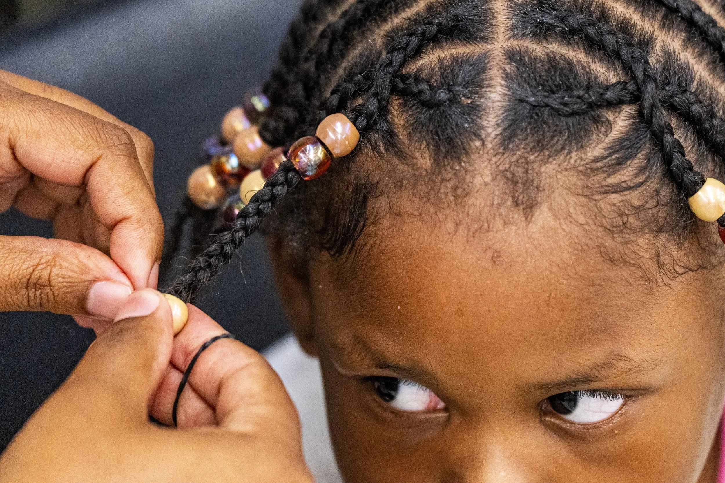 Shaquera Brown puts beads in Kiyomi Frazier’s, 4, hair during the2nd Annual Back2Skool event at the Jackson Police Training Academy in Jackson, Miss., on Sunday, July 26, 2026. 