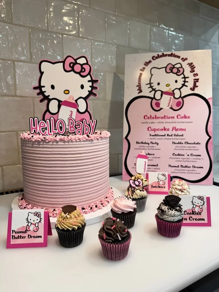 Hello Kitty themed birthday party with pink and white cake, cupcakes, and decorations featuring Hello Kitty holding a milk bottle.