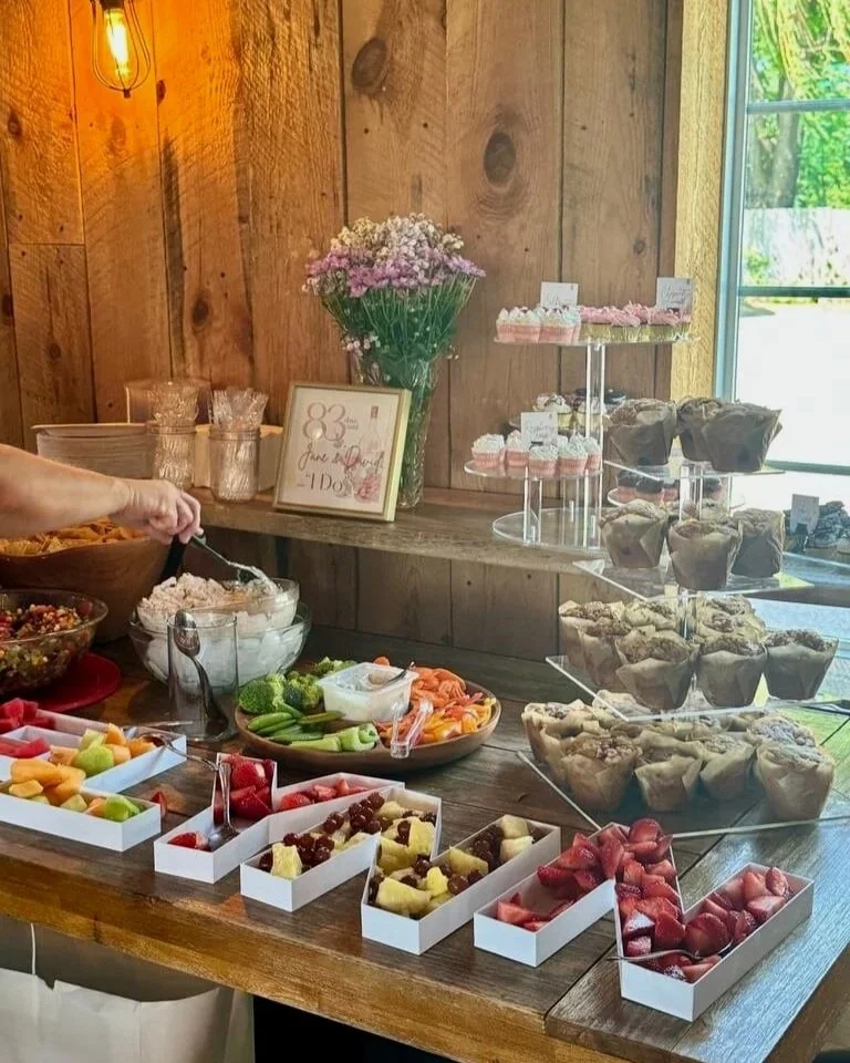 Dessert table with fruit, cupcakes, and muffins at a wedding or celebration
