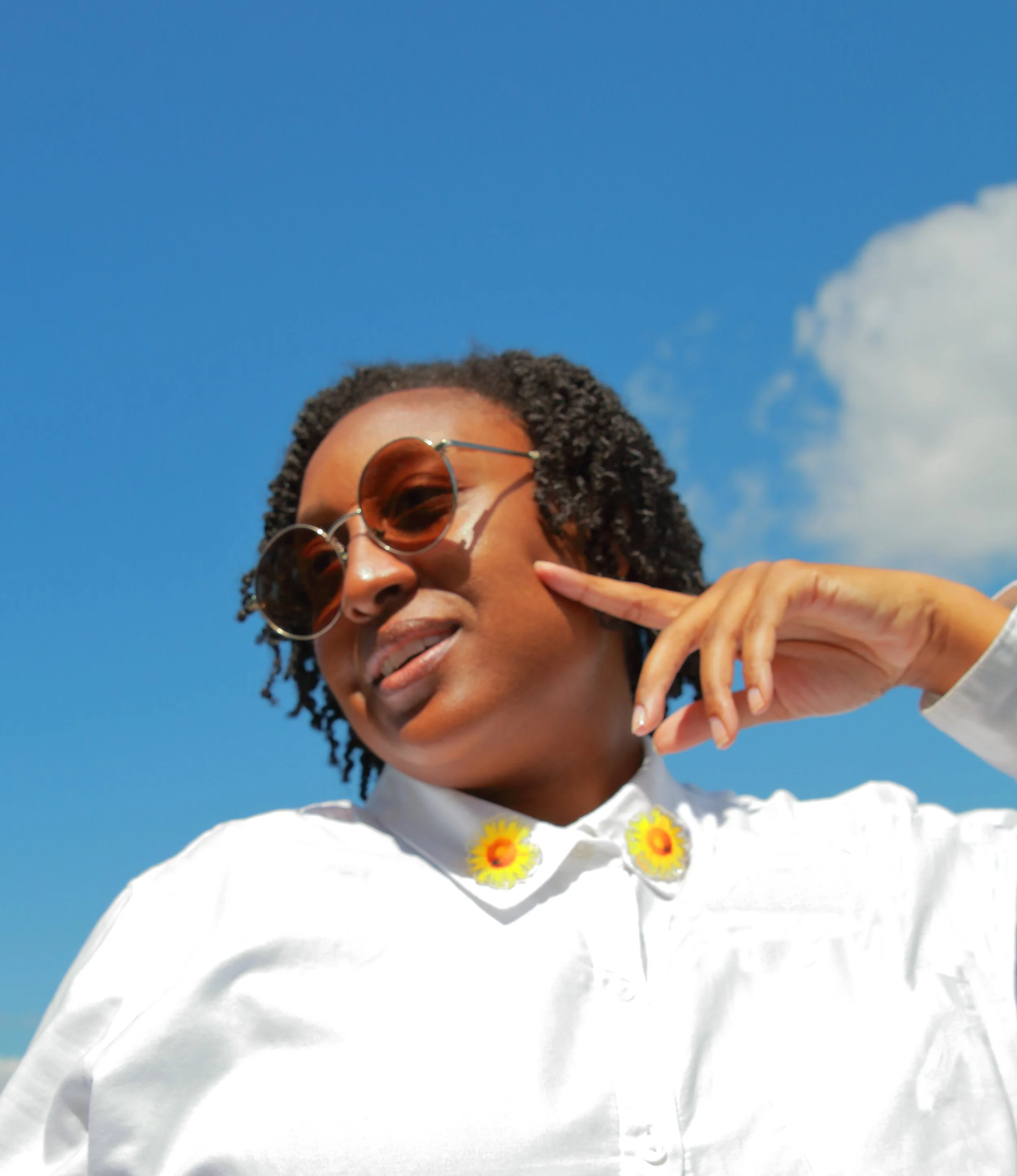 Black model wearing a sunflower pin.