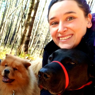 Image of employee Kyla with her posed with her two dogs