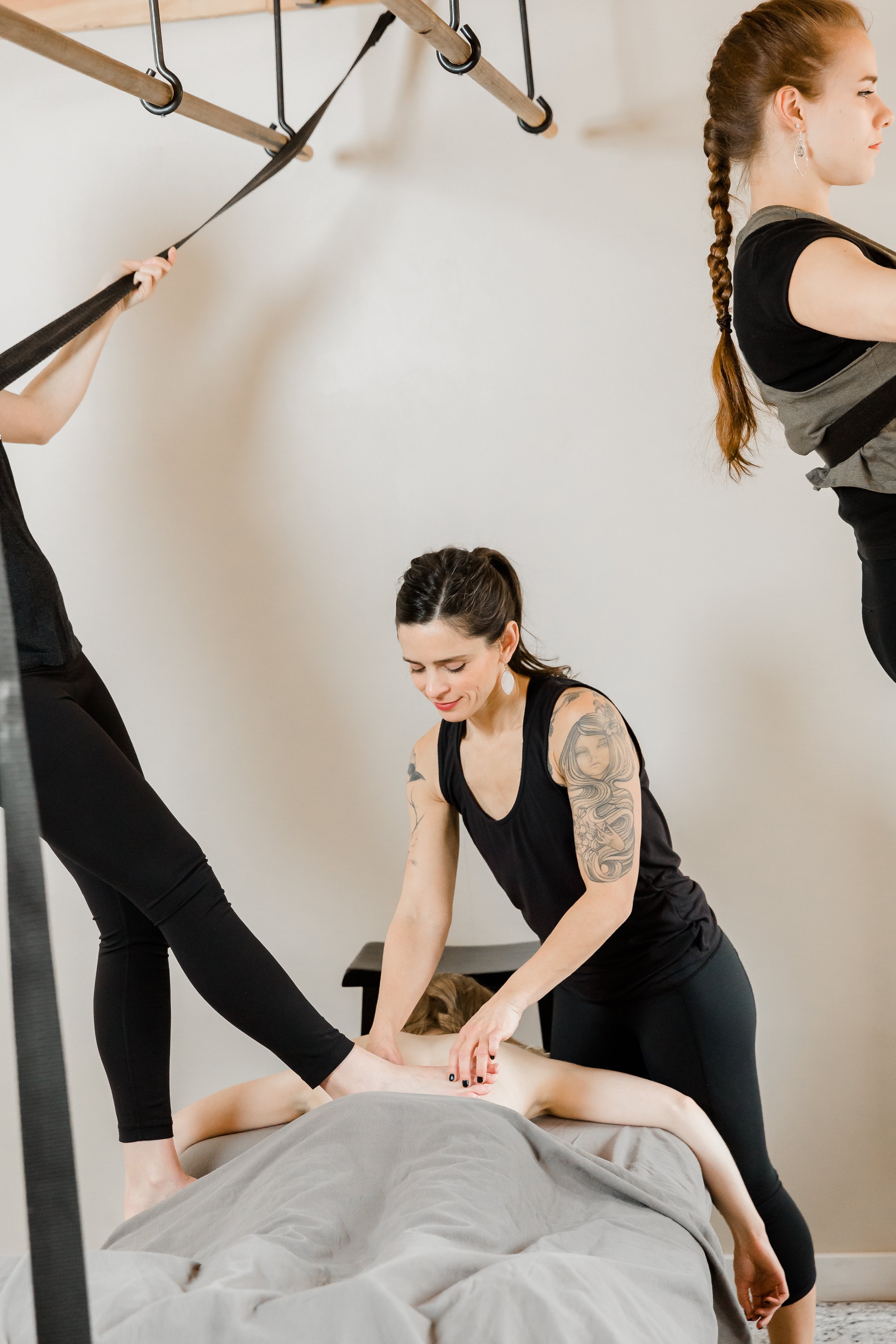 Mariah guiding a student's foot placement during barefoot massage training