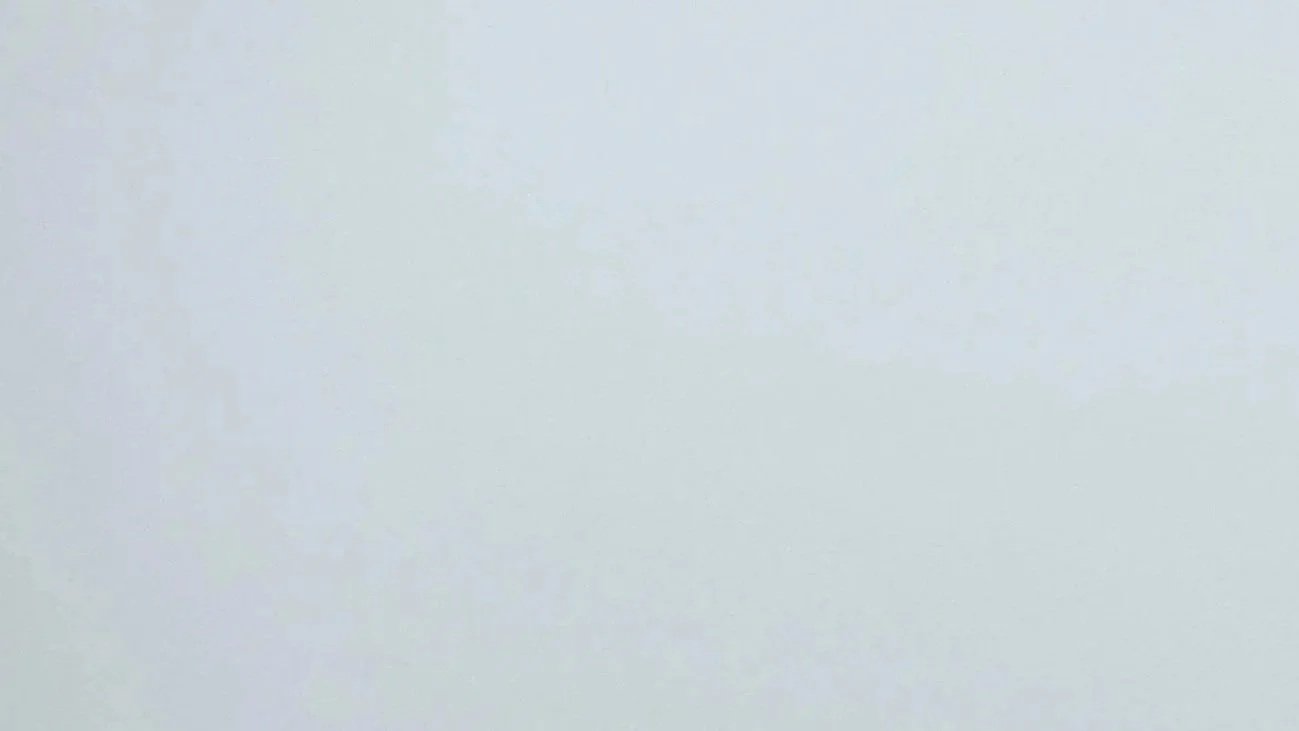 Light-colored, slightly textured surface with faint shadows.