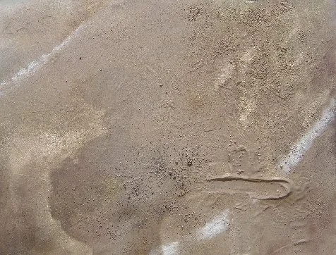 A tennis court with a ball mark on the surface.