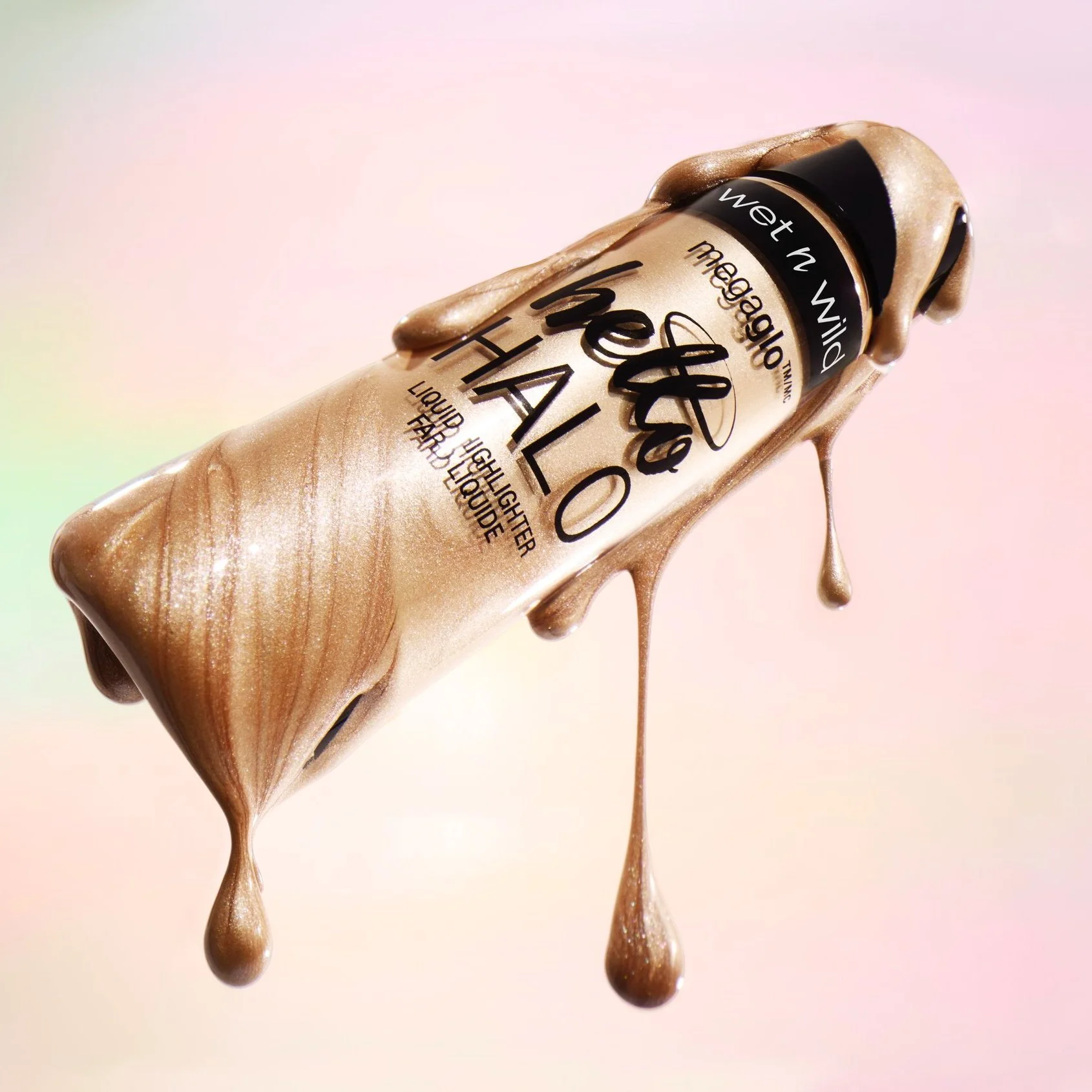 Wet liquid foundation spilling from a bottle labeled 'Make Up Heart Halo'. Product photography Los Angeles.